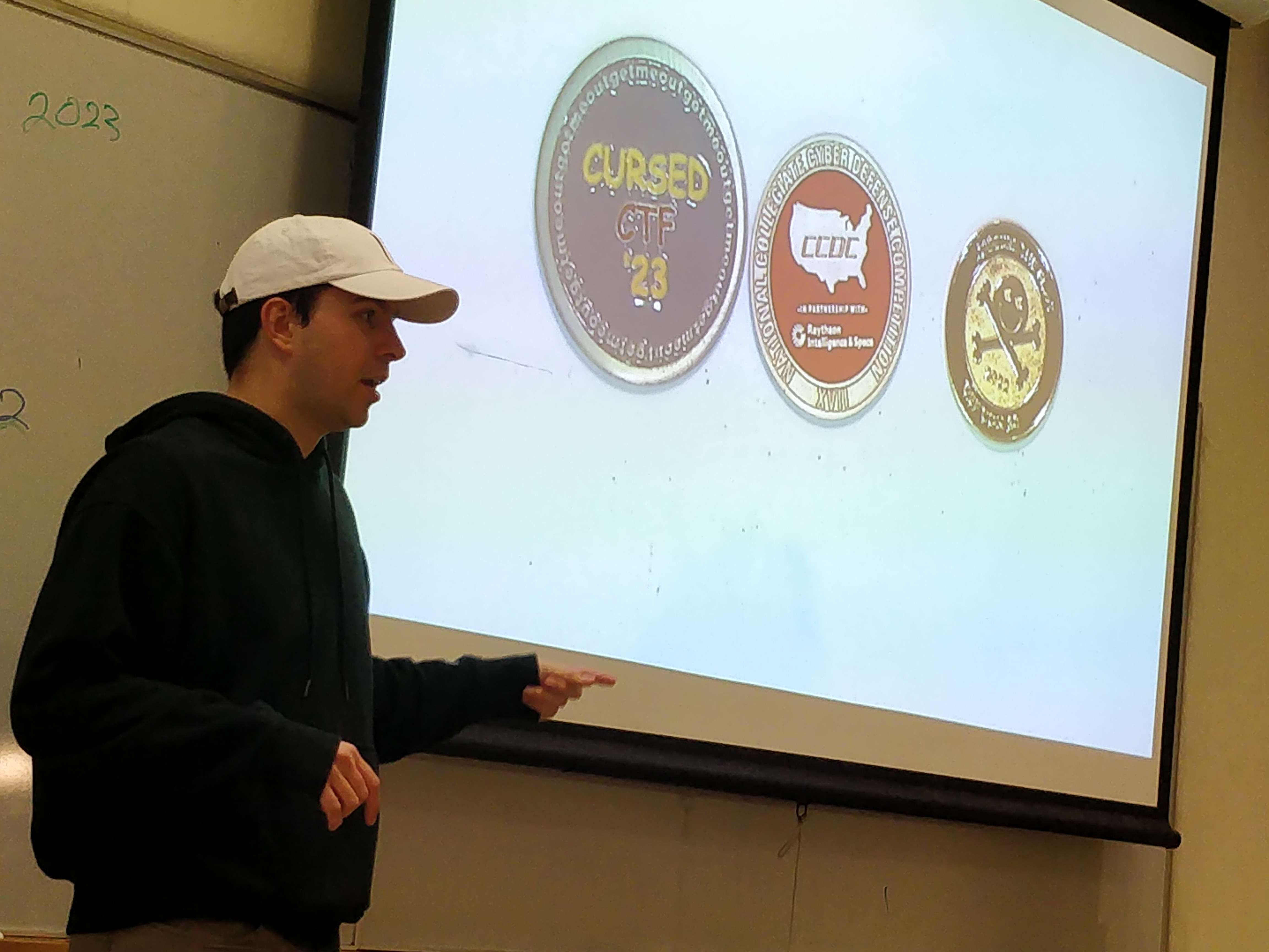 Photo of member Lucas Ball showing off challenge coins from various competitions